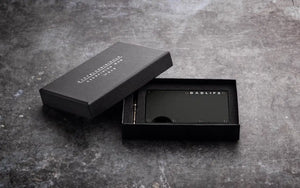 Zwarte DADLIFE cardholder op luxe marmeren achtergrond – stijlvol cadeau voor vader